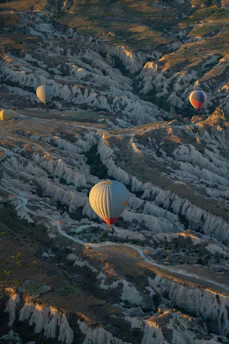 A vibrant sunrise over Cappadocia's fairy chimneys with hot air balloons drifting gently in the sky.