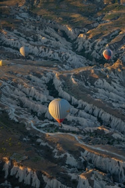 A warm sunrise over Cappadocia’s fairy chimneys with a hot air balloon drifting gently above.