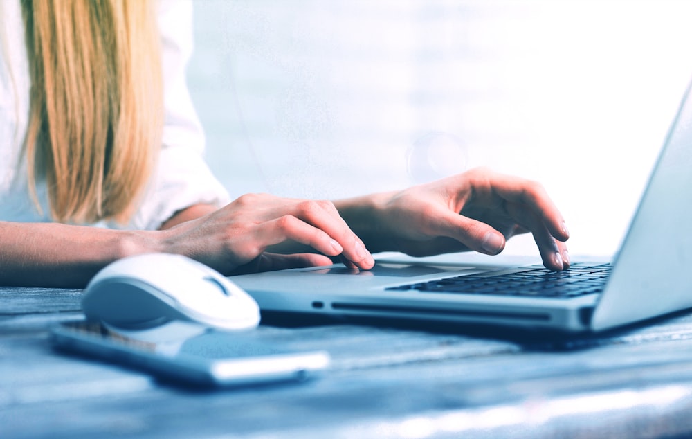 a woman is typing on a laptop computer