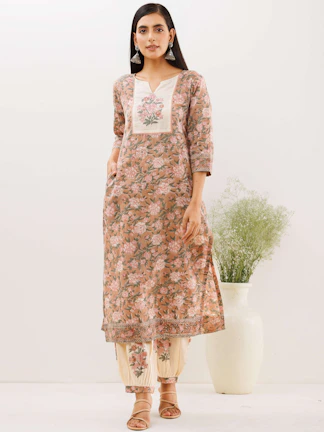Studio shot of a contemporary kurti with elegant patterns on a plain background.