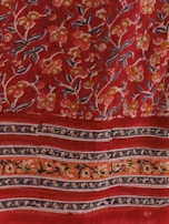 A vibrant red fabric featuring intricate floral patterns. The flowers are primarily yellow, white, and orange, with green leaves. The design includes parallel bands with floral motifs that stretch horizontally across the fabric.
