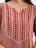 A close-up of intricate embroidery on a colorful Moroccan caftan fabric.