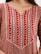 A close-up of intricate embroidery on a colorful Moroccan caftan fabric.