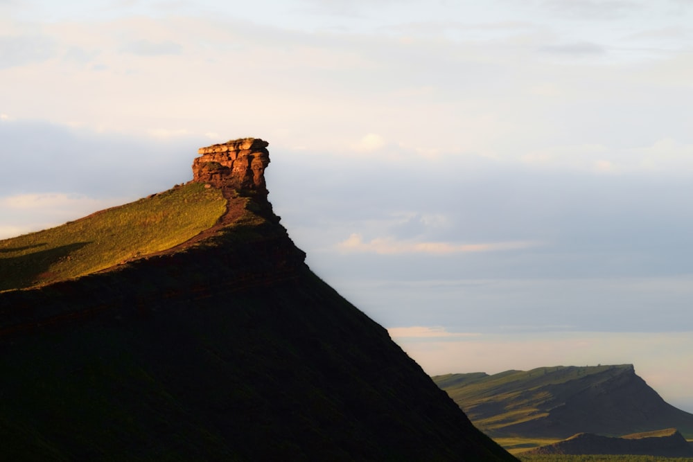 a hill with a rock formation on top of it