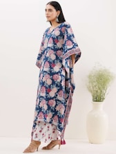 A bright, airy studio shot of a woman wearing a flowing dress and delicate jewelry from femiso.