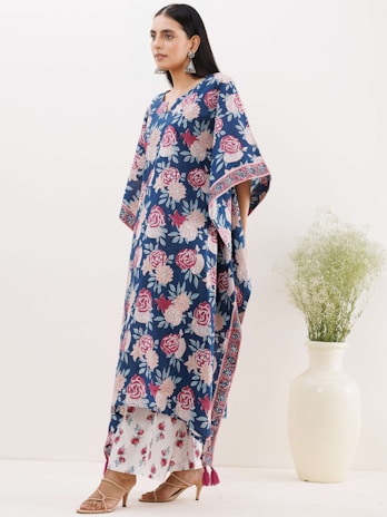 A stylish woman wearing a floral dress and matching accessories in a bright boutique setting