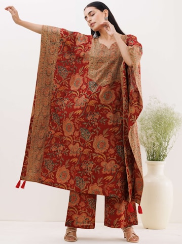 a woman wearing a red and orange paisley print dress