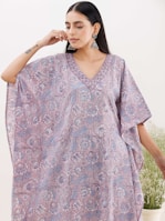 Model wearing a flowing Kaureen Atelier abaya in a serene outdoor setting.