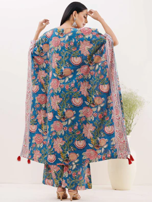 A model wearing a contemporary styled huipil standing against a neutral terracotta backdrop.