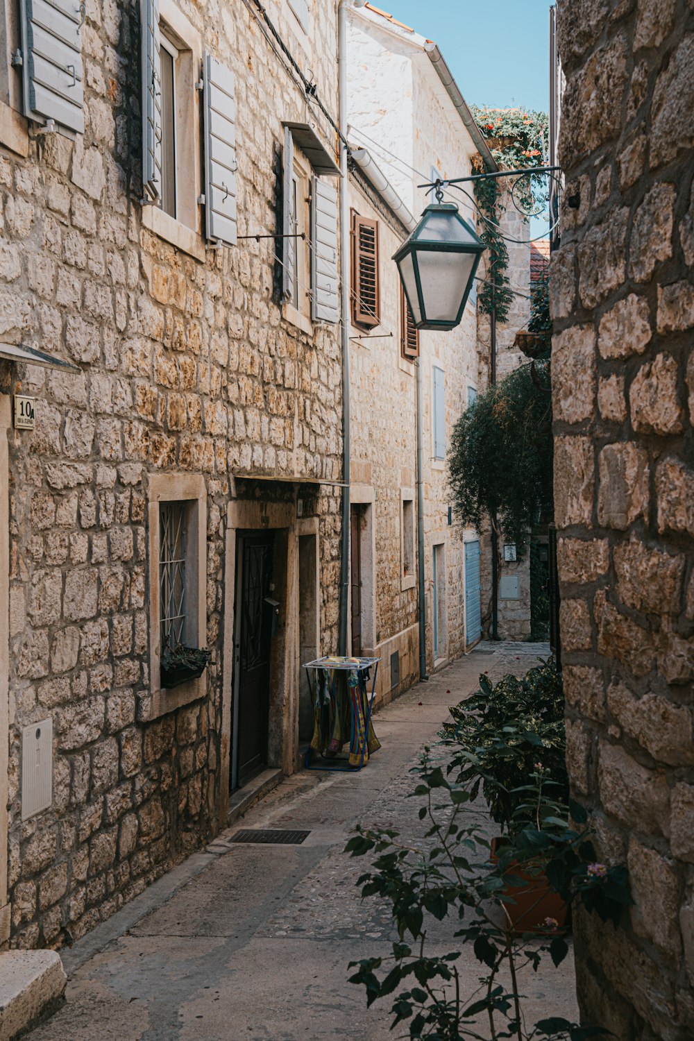 an alley way with a lamp post and stone buildings