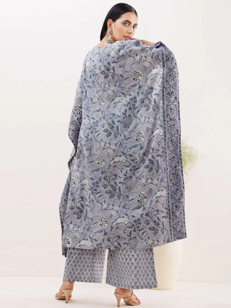 Close-up of a customer draped in a richly patterned Vastraaura shawl, standing by a window