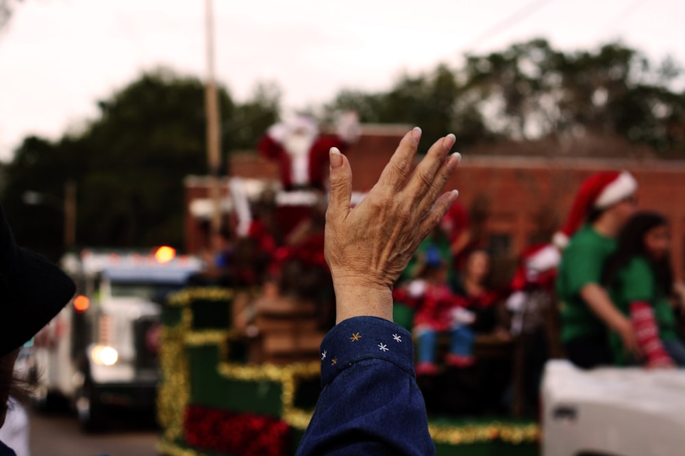 a person's hand in the middle of a parade