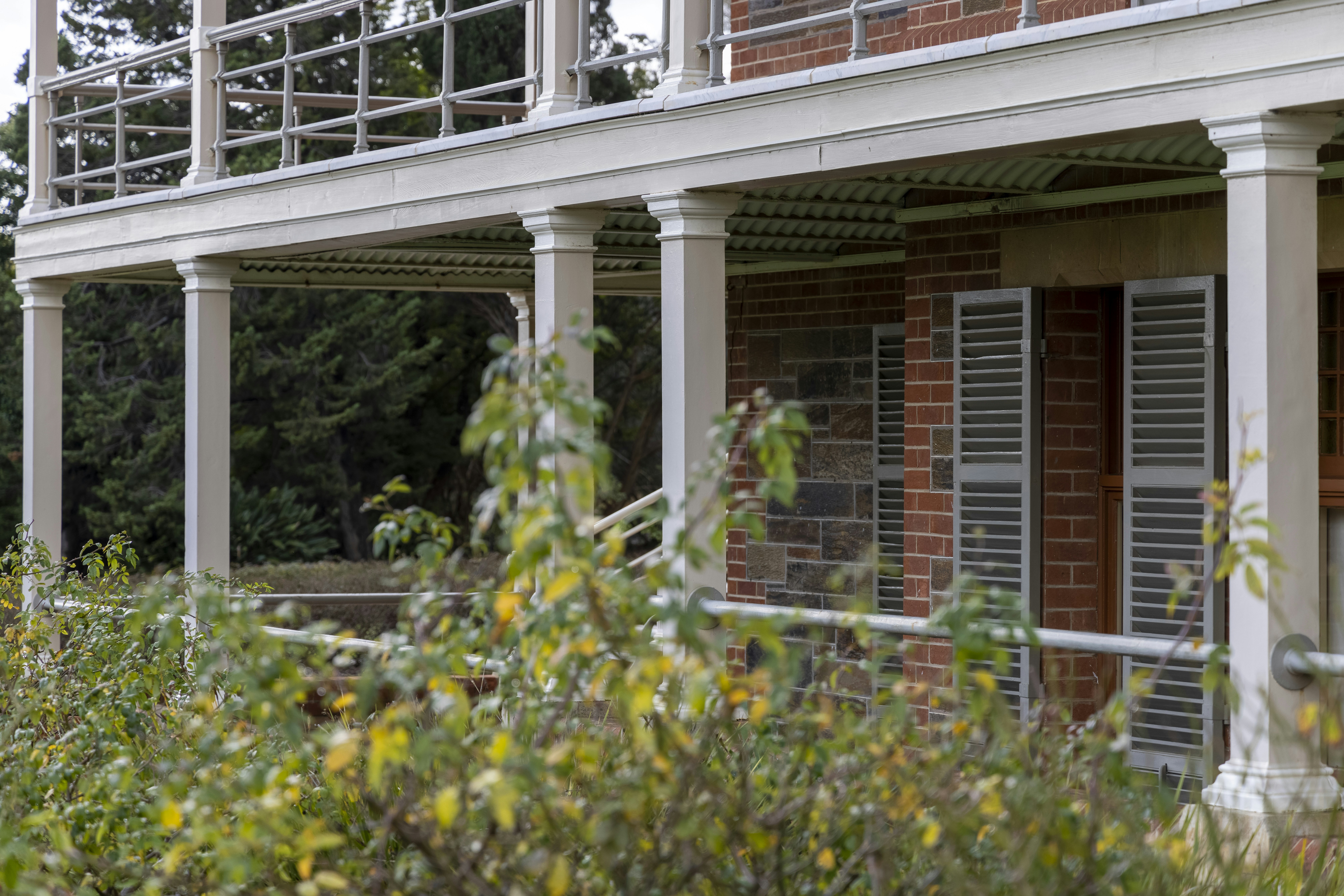 Brick house with columned verandah and shutters