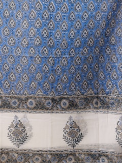 An intricate textile design featuring a repeating pattern of teardrop-shaped motifs on a blue background. The motifs contain detailed floral and leaf patterns, bordered by a series of elaborate floral designs. The bottom section features larger floral motifs on a white background, framed by a floral border.