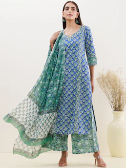 A colorful kurti pant with dupatta ensemble laid out on a traditional Jaipuri patterned fabric.