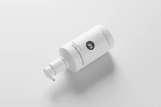A bottle of lotion on a white surface.