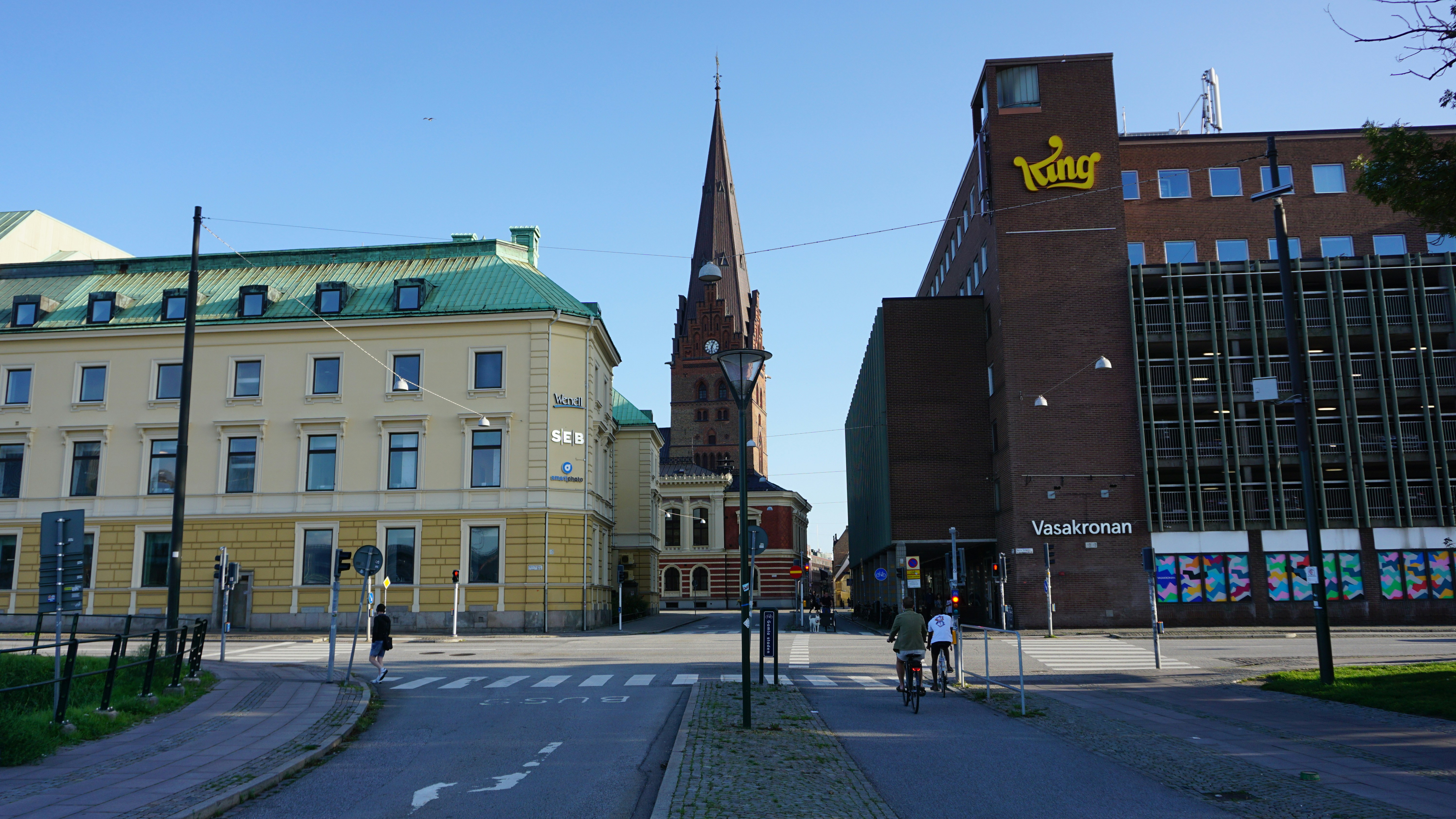 a city street with a church steeple in the background