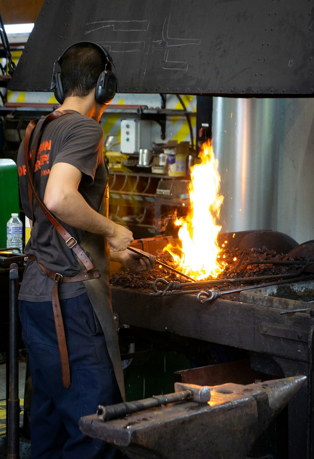 a man wearing headphones standing in front of a fire