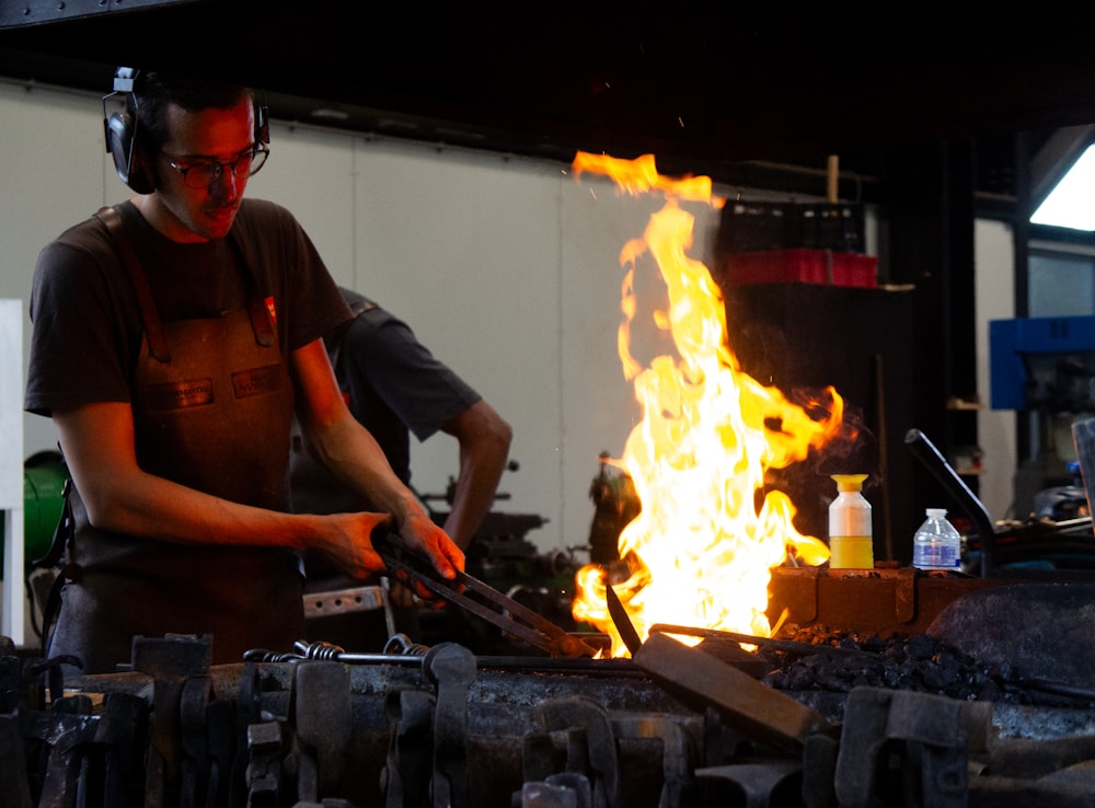 a man wearing headphones standing in front of a fire