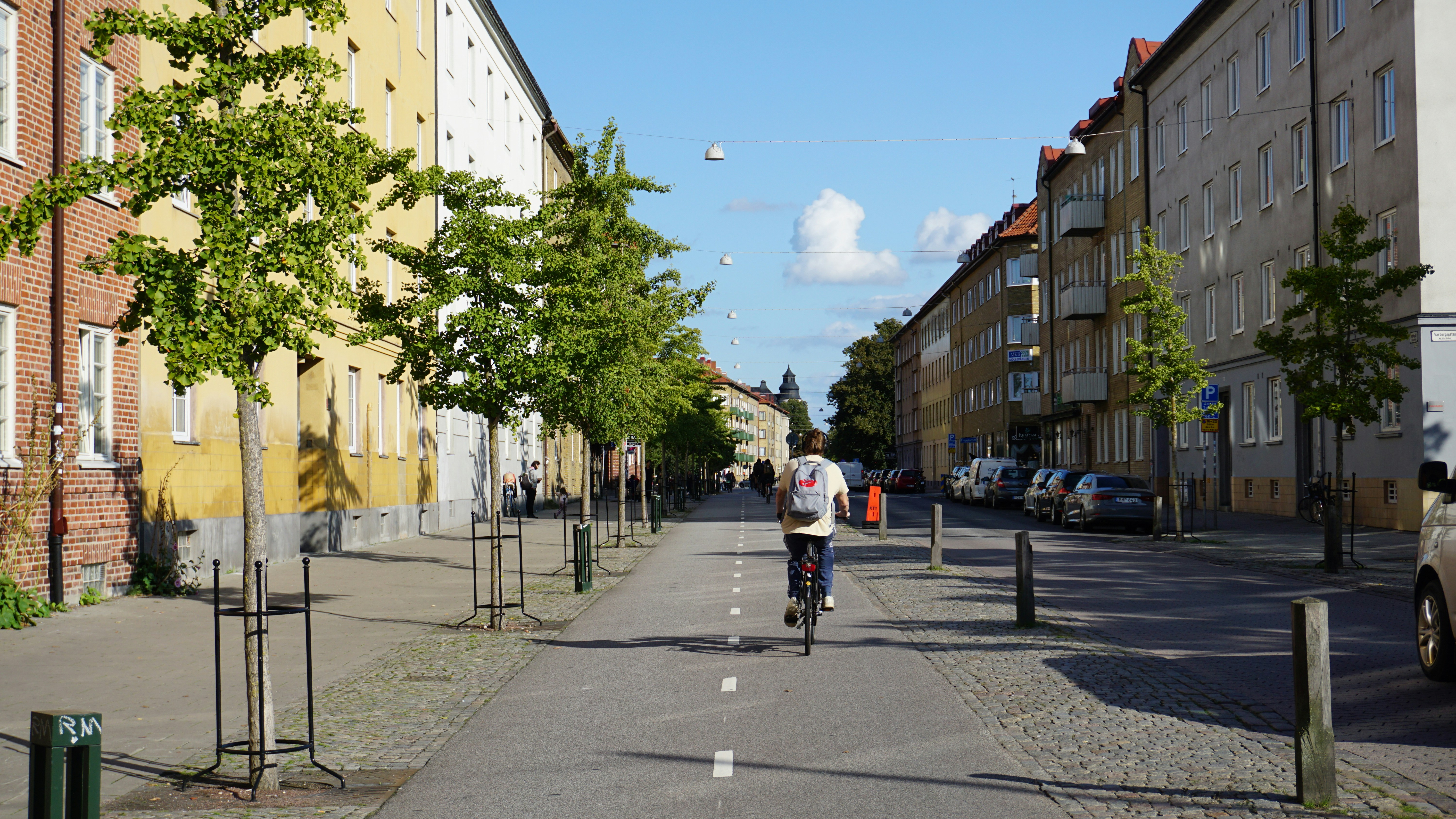a man riding a bike down a street next to tall buildings