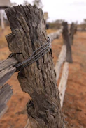 Close-up of hands securing fence posts during an installation.