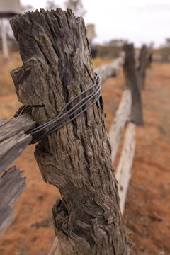Close-up of hands securing fence posts during an installation.