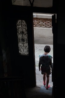 a young child standing in a doorway of a building