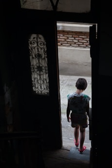 a young child standing in a doorway of a building