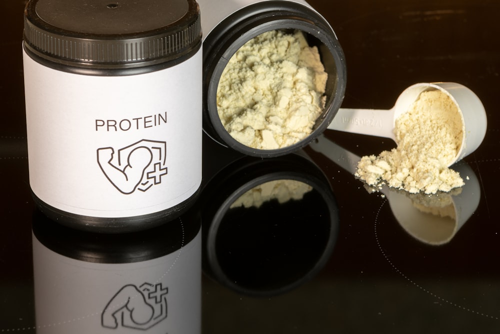 a jar of protein powder next to a spoon