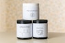 three jars of cream sitting on top of a table