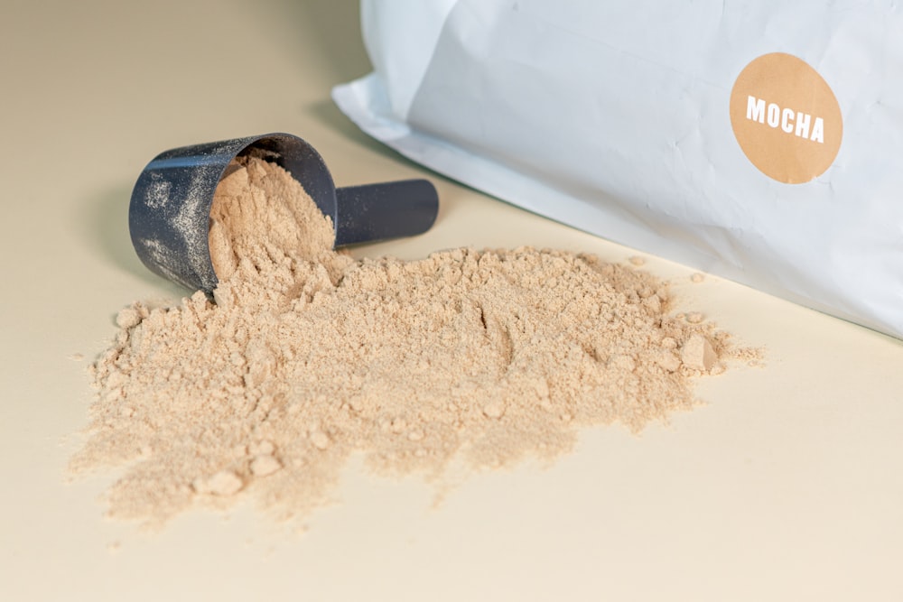 a scoop of powder next to a bag of powder