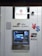 An ATM machine associated with the Bank of China (Hong Kong) featuring logos of various payment networks such as UnionPay, Jetco, Visa, and Plus. Above the machine, a surveillance camera is visible. The design is predominantly white with blue and metallic elements.
