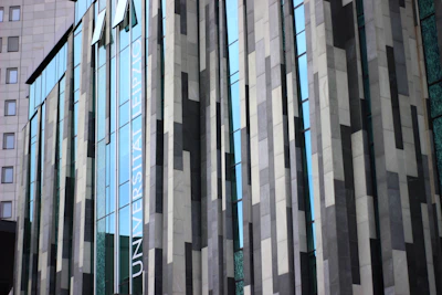 Modern glass facade of a commercial building with dark blue and transparent panels.