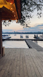 A custom ornamental lake with integrated lighting and wooden deck at sunset.