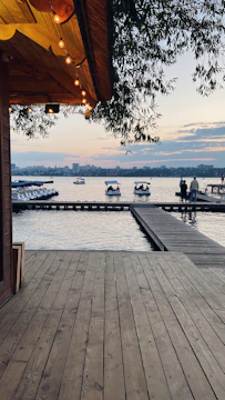 A custom ornamental lake with integrated lighting and wooden deck at sunset.