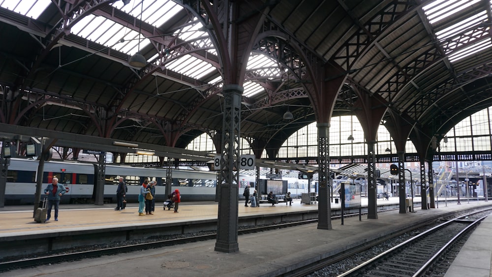 a train station with people standing on the platform