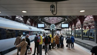 a group of people waiting for a train at a train station