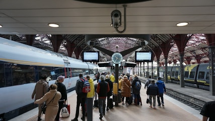 a group of people waiting for a train at a train station