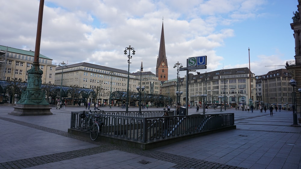 a city square with a clock tower in the background