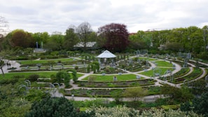 A peaceful garden area near the royal palace with blooming flowers and shaded benches