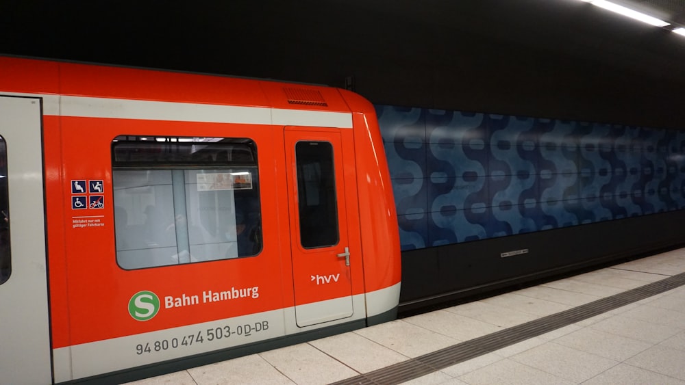 an orange and white train at a train station