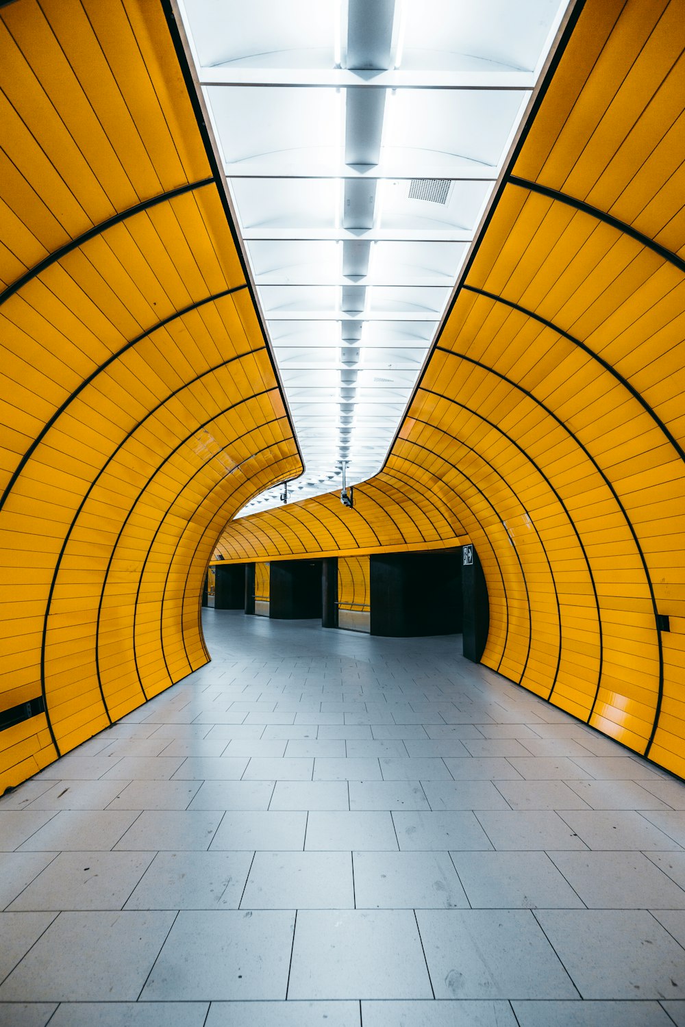 Un largo túnel amarillo con suelo de baldosas