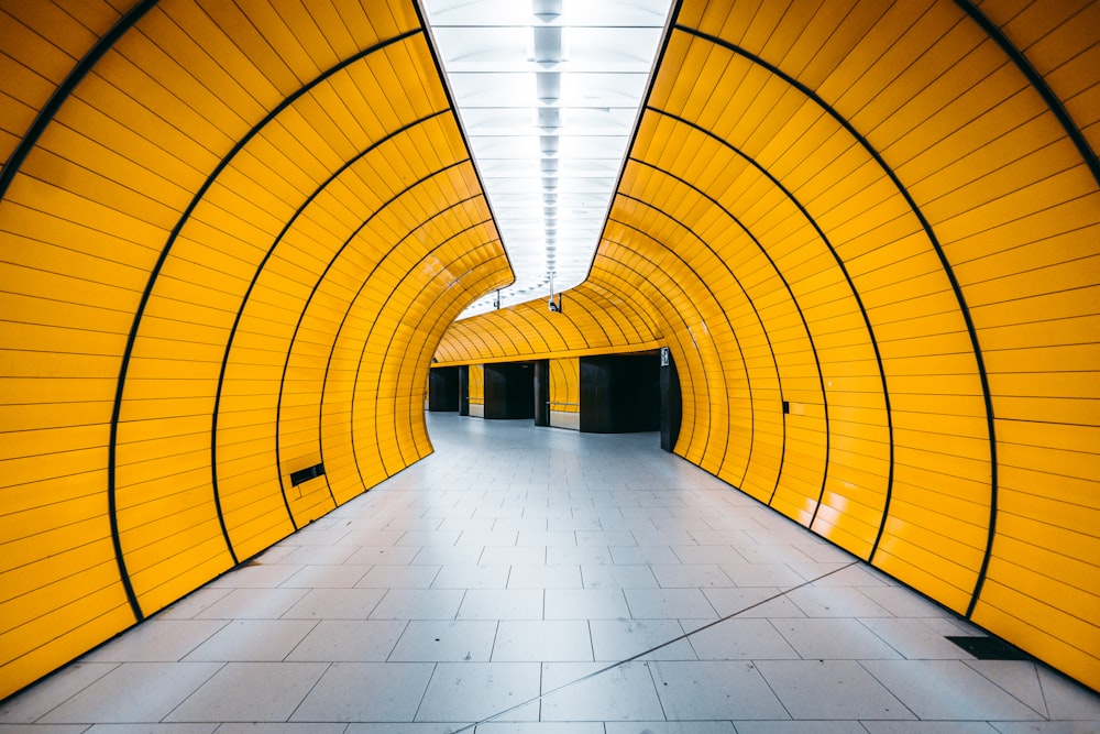a tunnel with yellow walls and a tiled floor