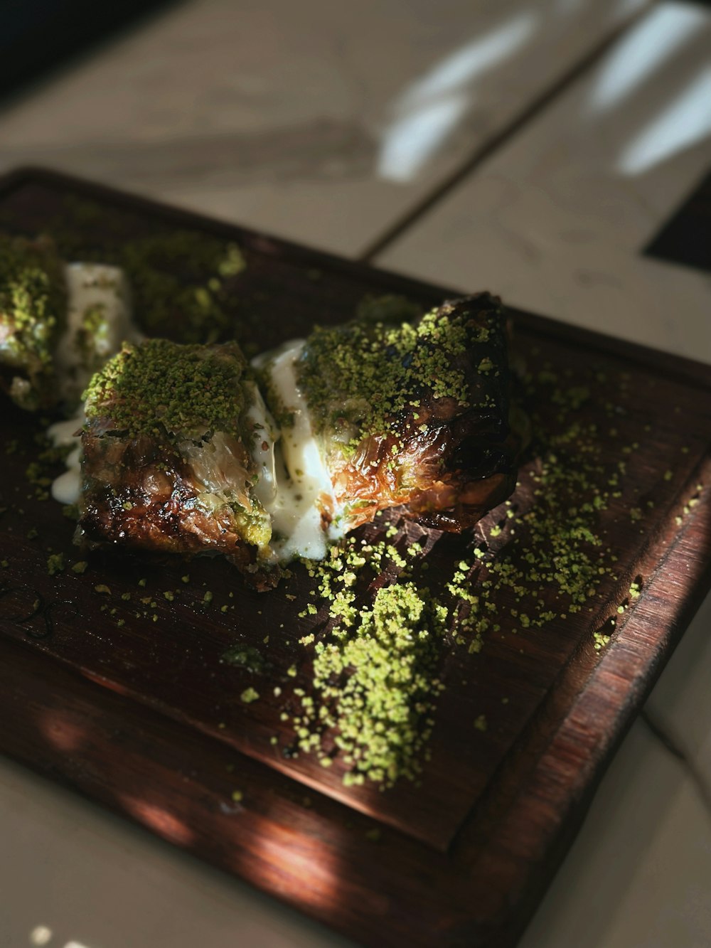a wooden cutting board topped with meat covered in green stuff