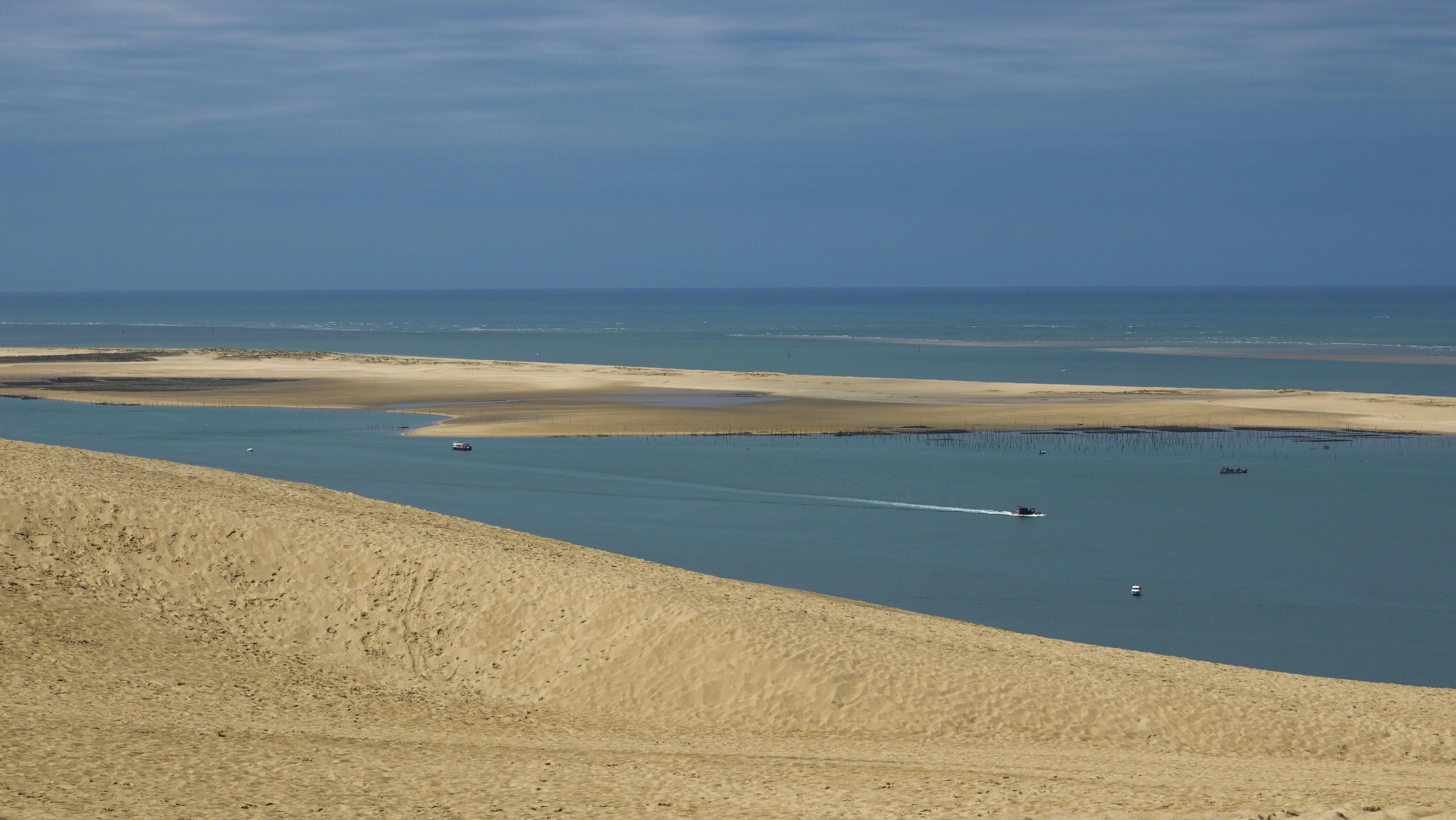una gran masa de agua rodeada de dunas de arena