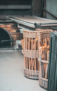 A warm stone oven with a baker shaping dough by hand, surrounded by woven baskets.