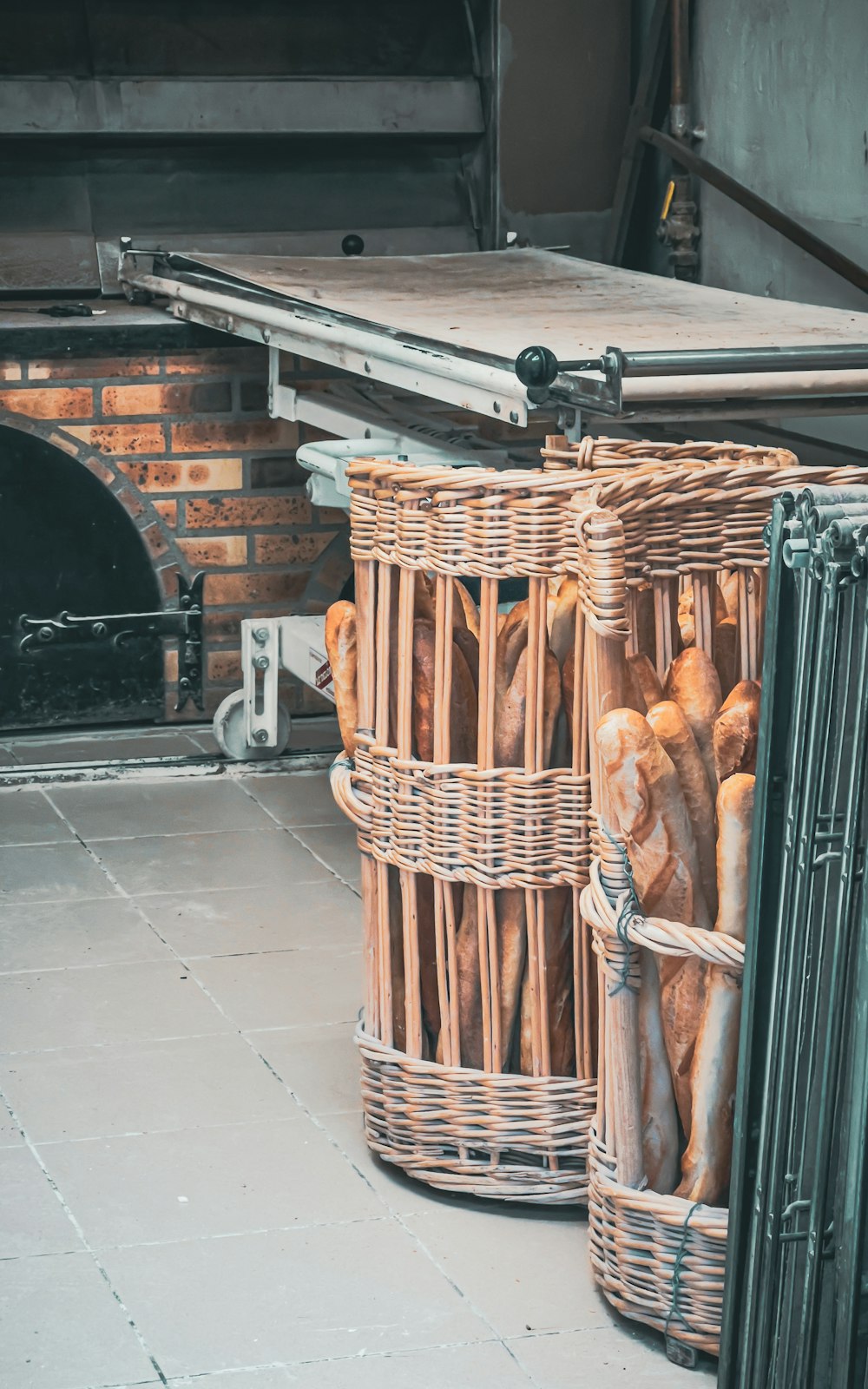 a bunch of breads in wicker baskets in front of a brick oven