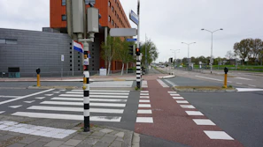 Volunteers placing clear pedestrian signs on a busy Maastricht street.