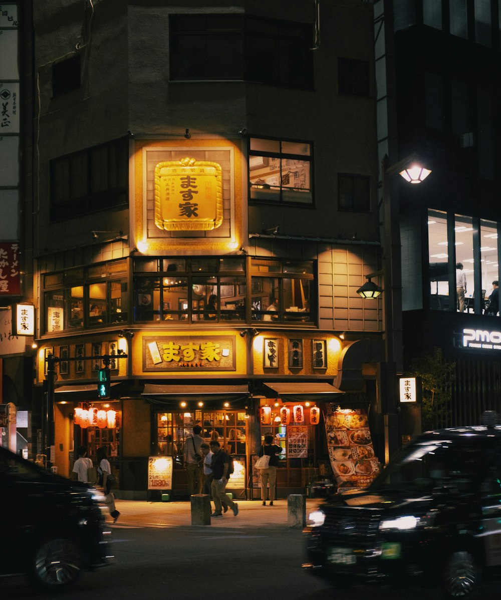 a chinese restaurant at night with cars parked in front of it