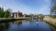 People practicing stand-up paddleboarding on the calm, crystal-clear waters of Canal do Itajuru.